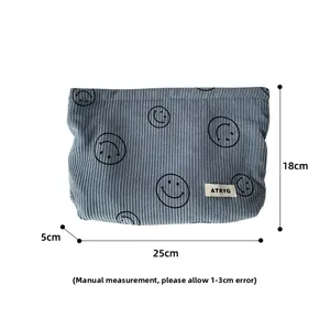 Blue corduroy makeup bag with smiley face detail and 25cm x 18cm x 5cm dimensions