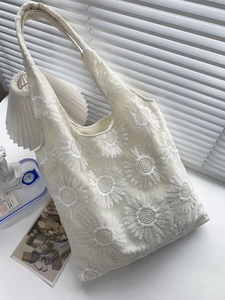 Gros plan d'un sac cabas en mesh crème avec broderie marguerite 3D et larges anses