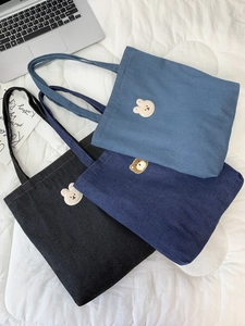 Detailed view of three denim tote bags with cute animal embroidery in different shades