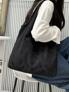 Close-up of black tote bag featuring delicate butterfly jacquard texture and thick fabric