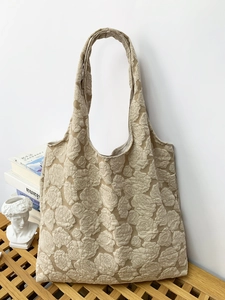 Macro detail of elegant embossed rose floral pattern on high-quality cream tote bag fabric