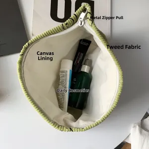 Detail of light green corduroy makeup bag with canvas lining and cosmetics inside