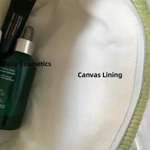 Detail of green corduroy makeup bag showing canvas lining and internal storage space