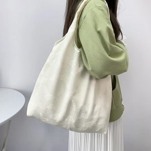 Detail of white butterfly jacquard texture on spacious canvas tote bag with wide strap