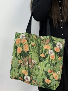 Detail of floral tapestry tote bag with intricate daisy patterns and woven shoulder strap