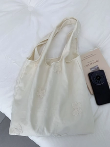 Détail du sac cabas en toile beige avec broderie papillon 3D et large poignée