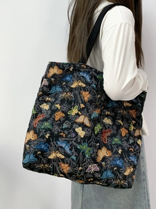 Detail of floral butterfly tapestry tote bag with textured fabric and wide shoulder strap