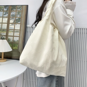 Close-up of white tote bag featuring delicate butterfly jacquard texture and fabric