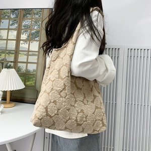 Macro detail of the embossed rose floral texture on a light brown tote shoulder bag