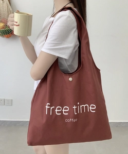 Close-up of red canvas tote bag with free time coffee print and metal snap button