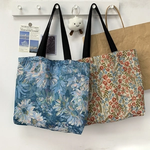 Detail of floral jacquard canvas tote bags in blue sunflower and red blossom patterns