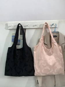 Chic butterfly embossed tote bags in black and pink on a minimalist display