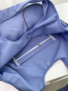 Blue canvas tote interior with zipper pocket, magnetic closure, and checkered trim detail