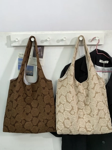 French style floral textured tote bag in dark brown and beige hanging on wall