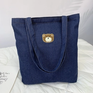 Dark blue denim tote bag with cute 3D brown plush bear embroidery on a white surface