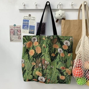 Close-up of green floral tapestry tote bag with white dandelion and daisy patterns