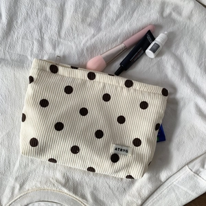 Macro shot of beige corduroy polka dot makeup bag with a high-quality metal zipper detail