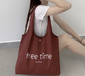 Detailed view of large canvas tote bag in dark red with silver snap button closure