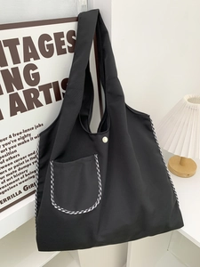 Minimalist black canvas tote bag with gingham trim and front pocket for daily commute