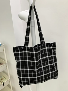 Vue détaillée du sac cabas en toile à damier noir et blanc avec doubles sangles solides