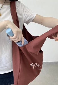 Detail of red canvas tote bag showing flee COFFEE print and spacious storage capacity