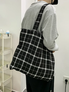 Détail du sac cabas en toile à damier montrant sa grande capacité et son motif rétro