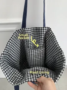 Détail du sac en jean montrant la doublure en coton vichy et une poche intérieure