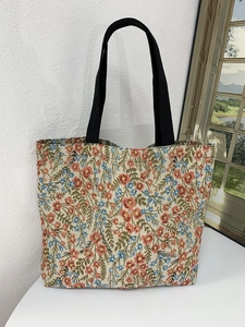 Detail showing the large capacity tote bag with Monet garden floral print and black straps