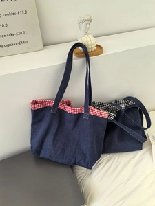 Détail du sac cabas en denim bleu avec empiècements en tissu vichy rouge et noir