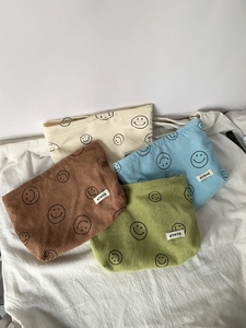 Corduroy dot cosmetic bags with smile patterns in white, blue, brown, and green colors