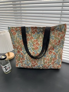 Close-up of the woven floral Monet-style pattern and texture on a blue tote bag