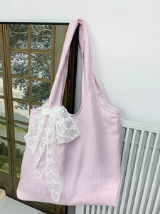 Detail of pink and white striped seersucker tote bag with large white lace bow decoration