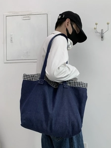 Détail macro du tissu denim bleu profond avec bordure à carreaux noir et blanc sur le sac