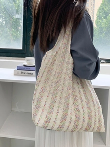 Close-up of neon colorful knit canvas tote bag with textured hollow weave and striped pattern