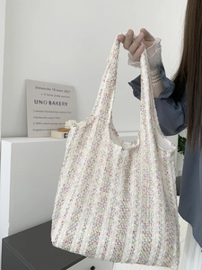 Detail of white lace tote bag with neon stripes and elegant pleated knitted texture
