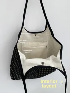 Detail of checkered tote bag interior with snap closure and zippered safety pocket