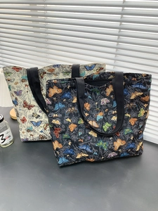 Detail of vintage butterfly jacquard fabric on large tote bags in black and cream colors