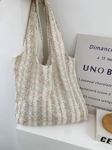 Close-up of a white crochet tote bag featuring intricate floral mesh and colorful accents