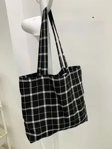 Détail du sac fourre-tout en toile à damier noir et blanc avec doubles poignées robustes