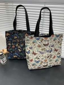 Close-up of butterfly printed canvas tote bags in black and cream for daily commute