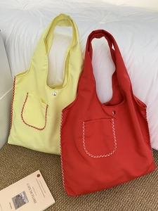 Close-up of nylon tote bags with gingham trim, outer pocket and silver snap fastener