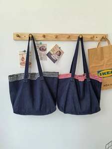 Détail de cabas en denim avec patchwork à carreaux rouges et noirs et larges bandoulières