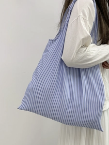 Gros plan du grand sac cabas en toile avec rayures verticales bleues et blanches