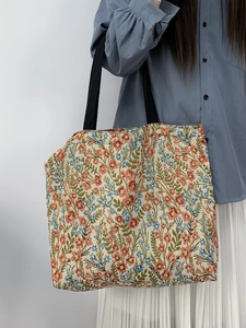 Detail of vintage floral jacquard tote bag with blue sunflowers and black shoulder strap