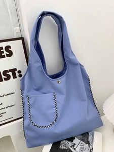 Light purple canvas tote bag with black and white checkered trim and magnetic closure