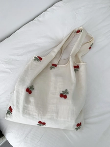 Detailed view of cherry blossom embroidery on off-white canvas tote bag for women