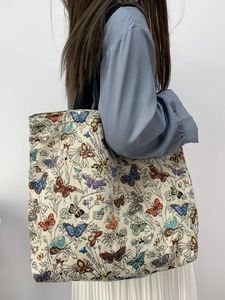 Detailed embroidery of colorful butterflies on a woven tote bag for daily use