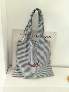 Detail of Peachy! red text print on striped nylon tote bag with high-quality stitching