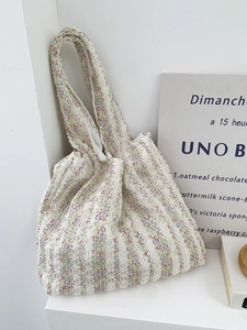 Detail of colorful hollow-out knit tote bag featuring vibrant stripes and bohemian patterns