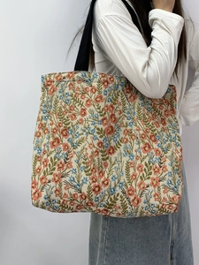 Detail view of large tote bag in floral jacquard fabric with thick woven shoulder strap